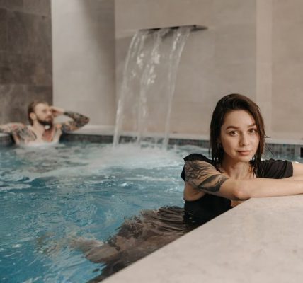 A couple enjoying a relaxing moment together in an indoor pool with a waterfall.